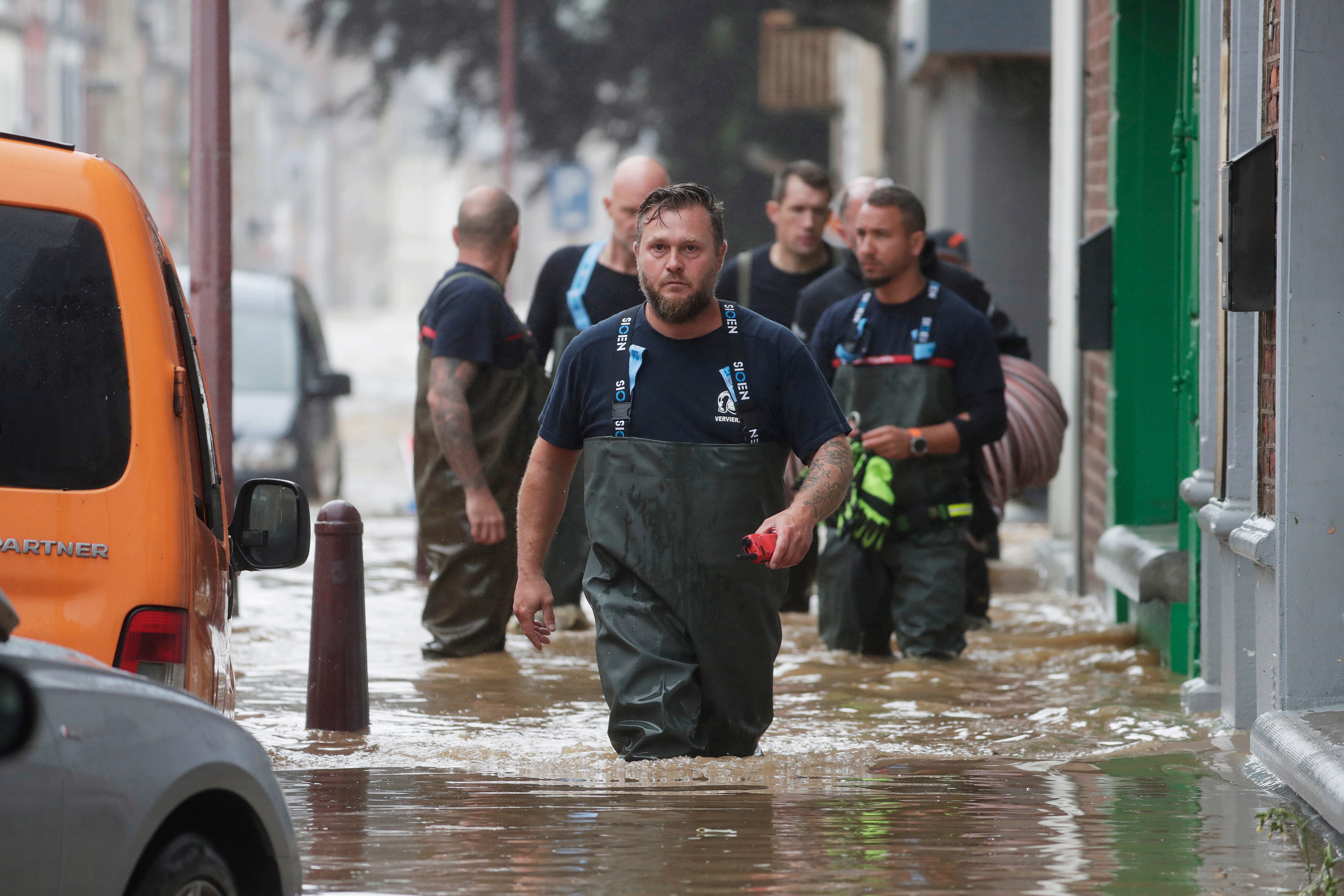 Emergency workers wade through the water in Ensival