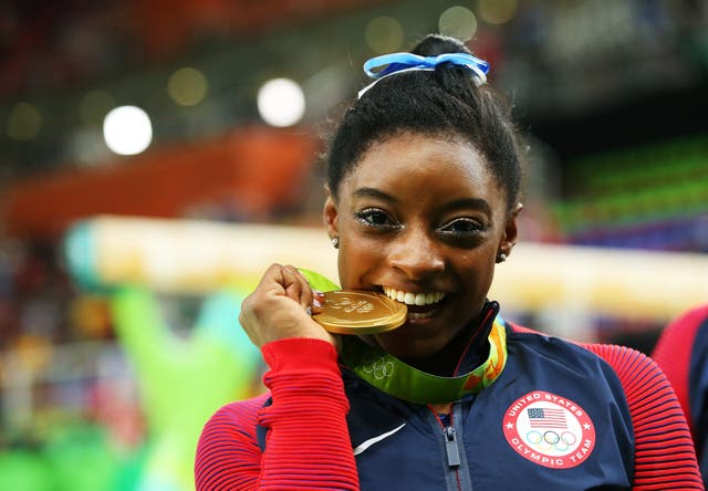 <p>Gold medalist Simone Biles of the United States poses for photographs after the medal ceremony for the Women's Individual All Around on Day 6 of the 2016 Rio Olympics at Rio Olympic Arena on August 11, 2016 in Rio de Janeiro, Brazil. (</p>
