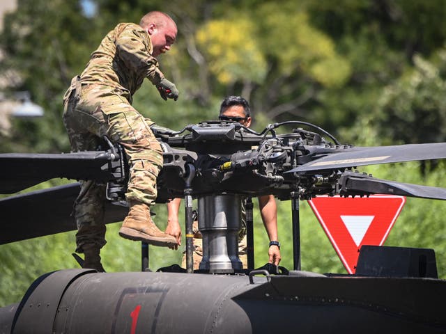 <p>Military personnel inspect a Black Hawk helicopter at Charles de Gaulle square in Bucharest on July 15, 2021, after it forced landed, apparentlly due to loosing power during a mission flight over the city.</p>