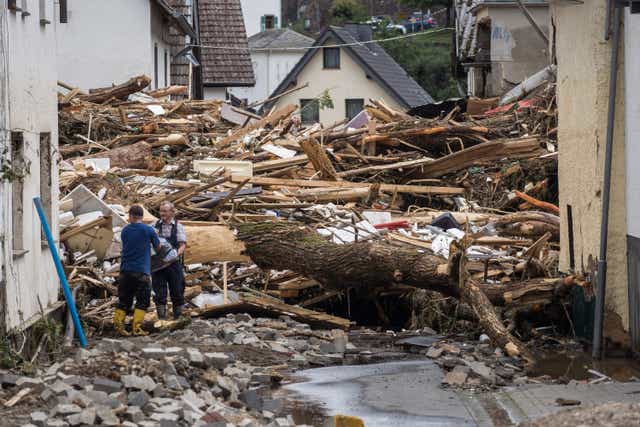 <p>Dos hombres mueven escombros después de que las casas fueran destruidas en Schuld, Alemania.</p>