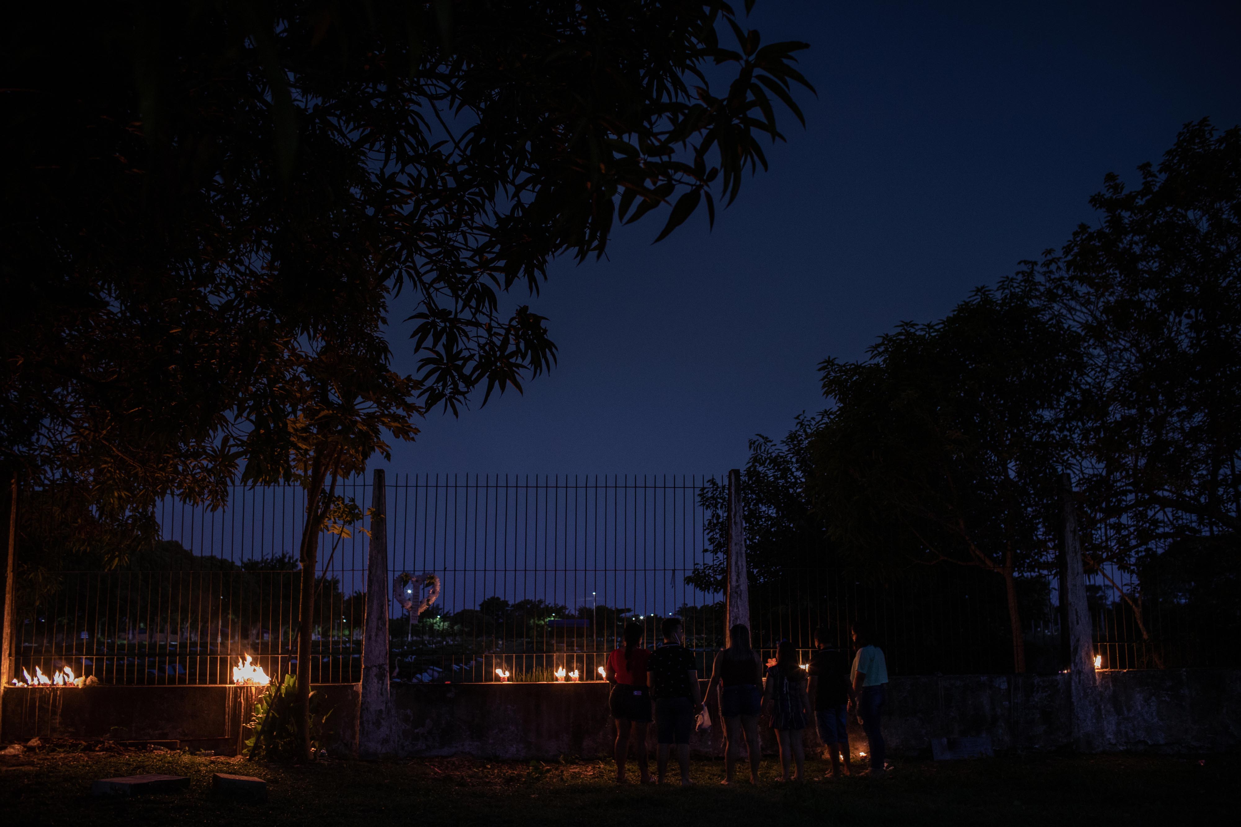 Mourners light candles outside a cemetery in Manaus for the city’s 9,200 Covid-19 victims