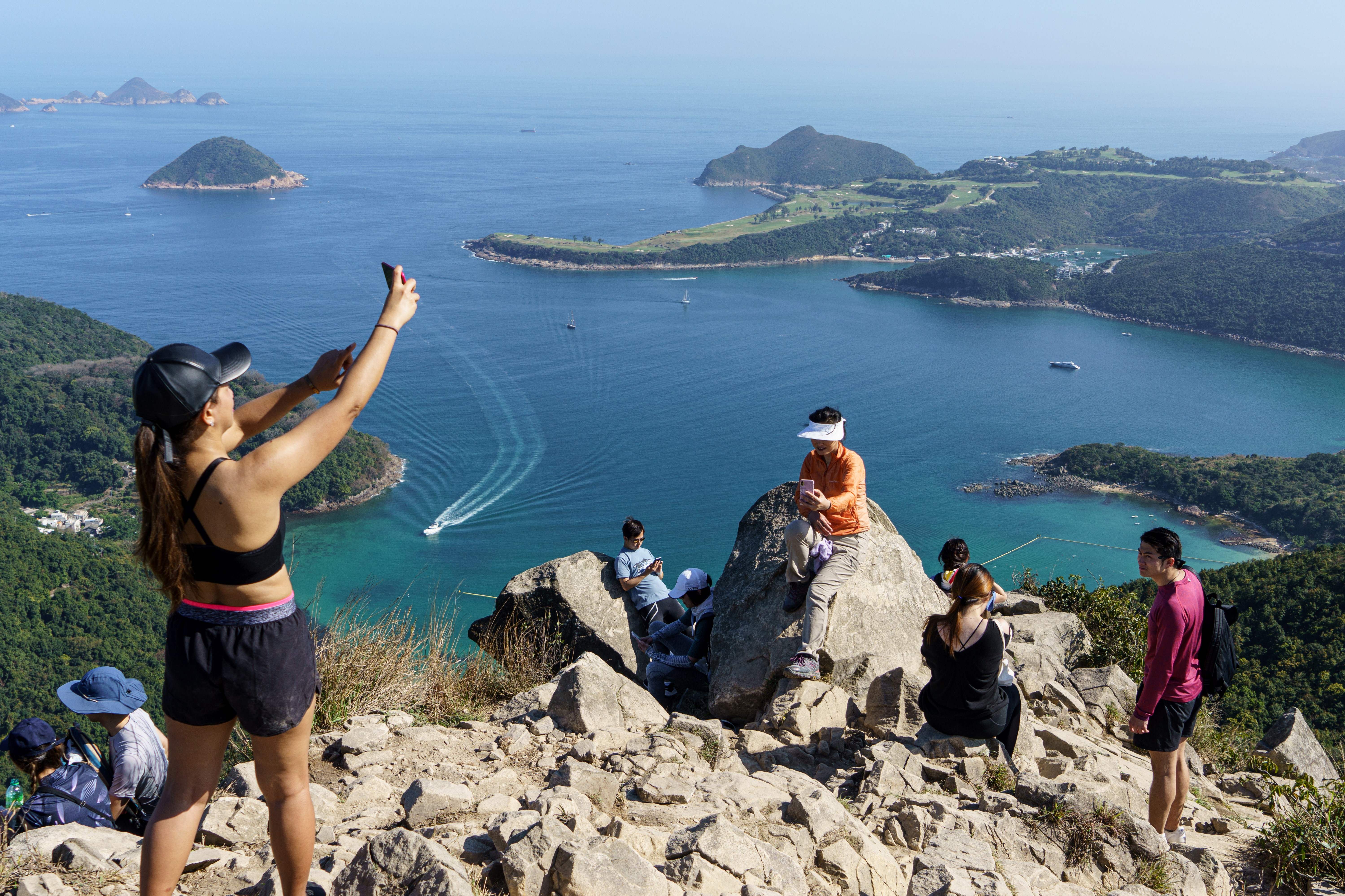 Representative: In this 29 February 2020 photo, hikers take pictures on High Junk Peak overlooking Clearwater Bay in the Tsuen Kwan O area of Hong Kong