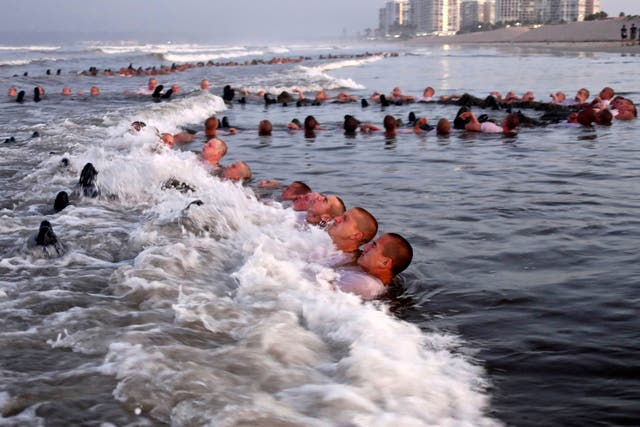 <p>In this May 4, 2020 photo provided by the US Navy, SEAL candidates participate in “surf immersion” during Basic Underwater Demolition training.</p>
