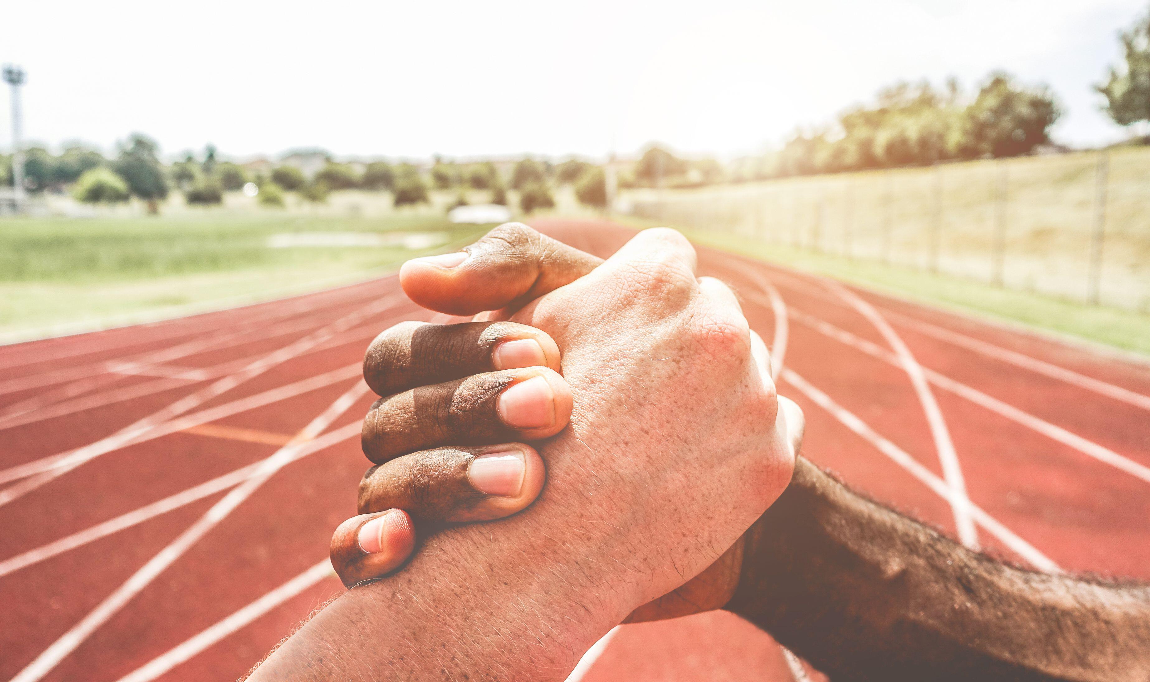 Hands clasped on an athletics track