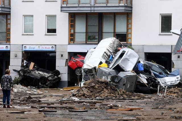 <p>A woman looks at cars and rubble piled up in a street after the floods caused major damage in Bad Neuenahr-Ahrweiler, western Germany</p>