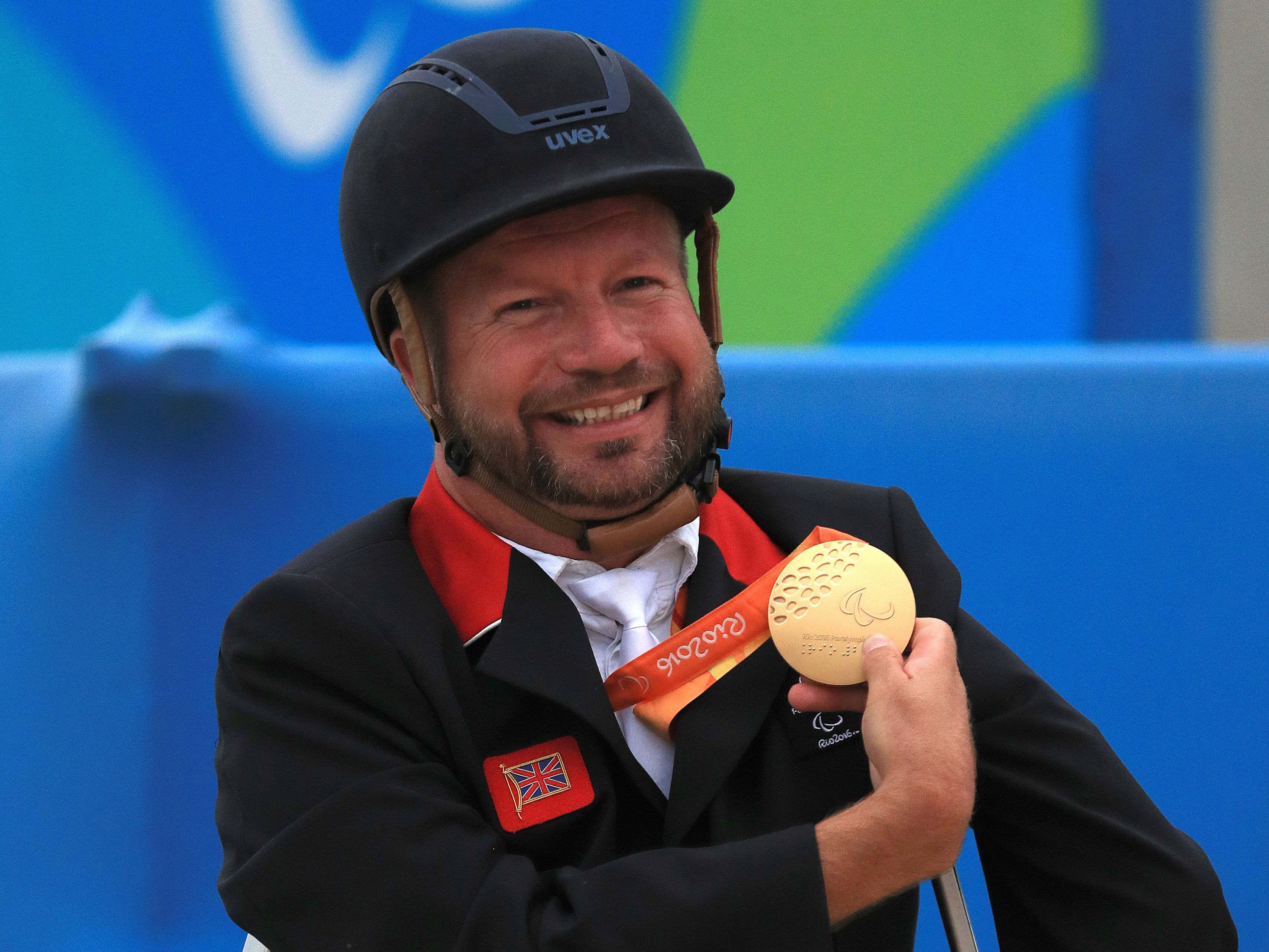 Lee Pearson celebrates with a medal