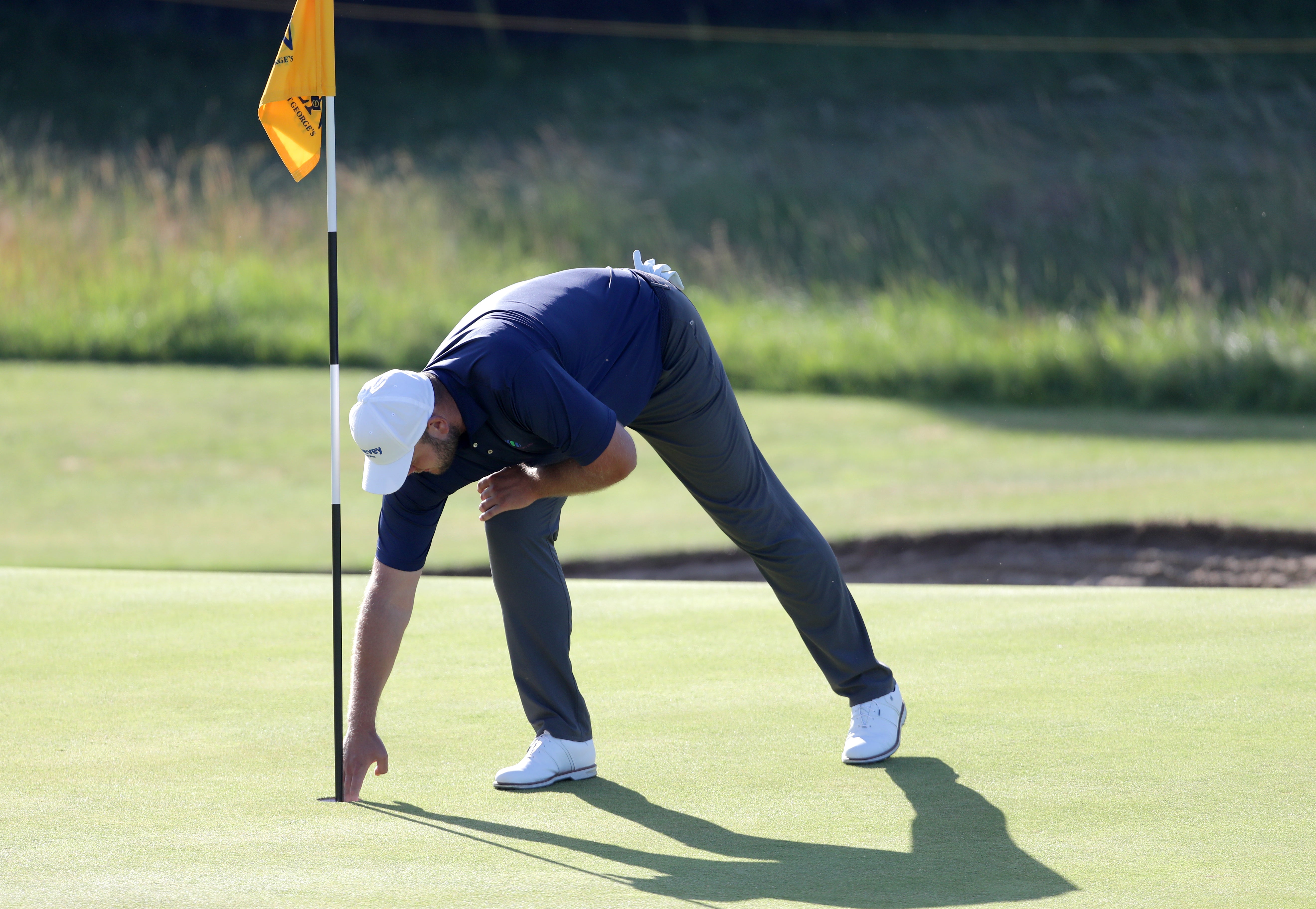 Jonathan Thomson picks his ball out of the cup after a hole in one at The Open