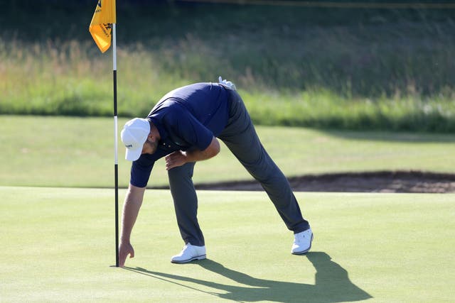 <p>Jonathan Thomson picks his ball out of the cup after a hole in one at The Open</p>