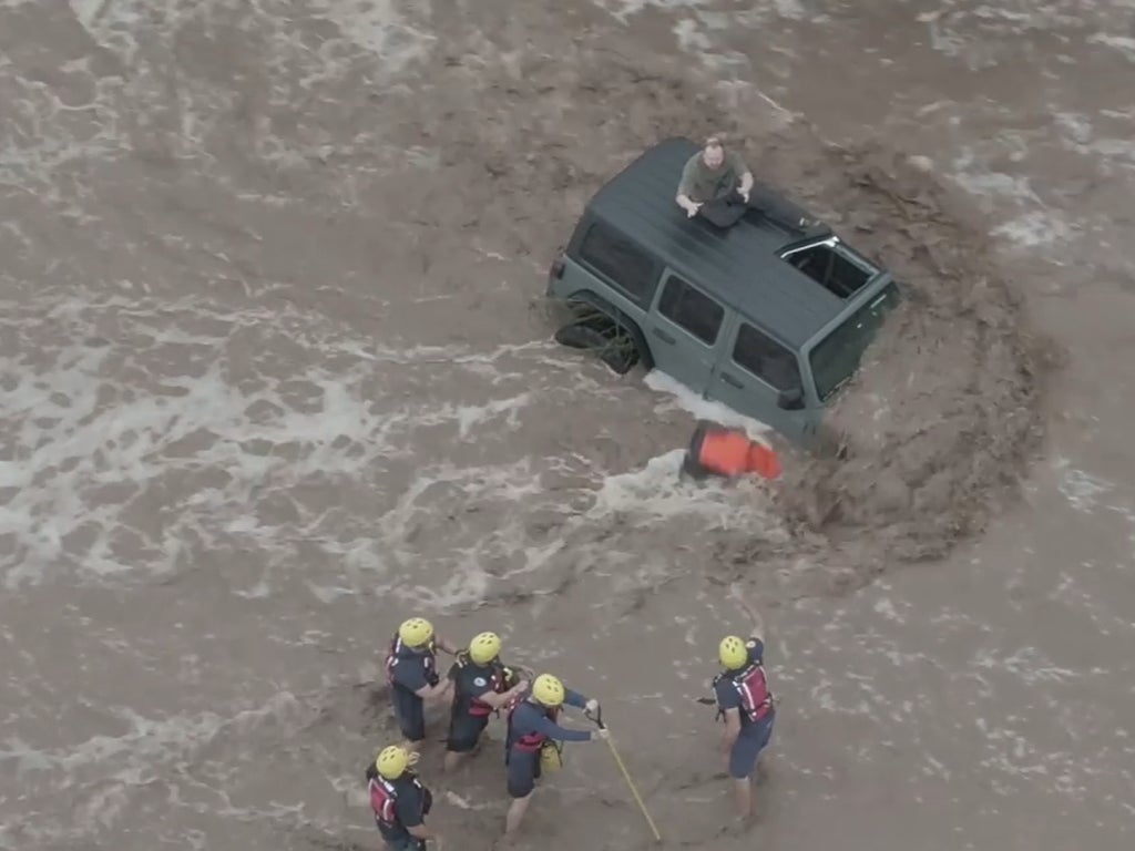 Dramatic videos show impact of Arizona flooding as family rescued from roof of car