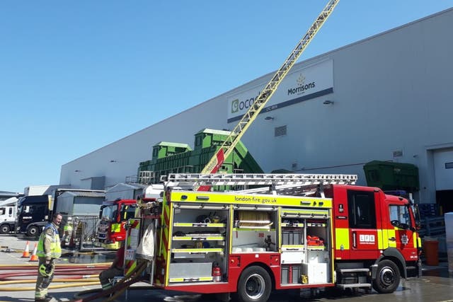 <p>Firefighters tackle a ‘very deep-seated’ blaze at the depot in Erith, south London</p>