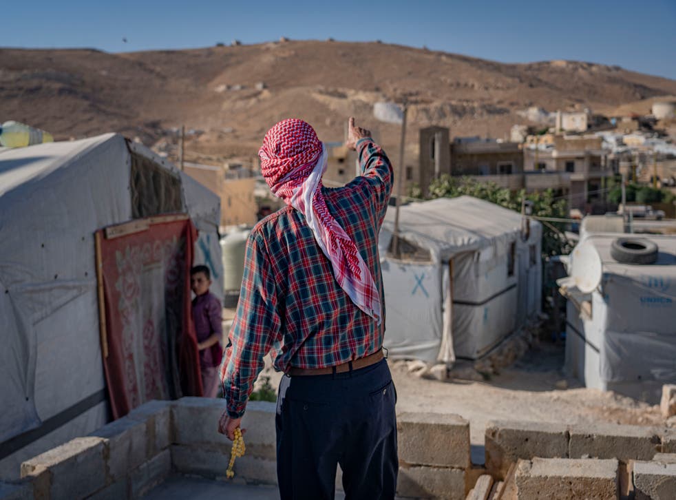 <p>Abu Abdu, a Syrian refugee, points to Syria, where he plans to return, as he says his life in Lebanon is so hard</p>