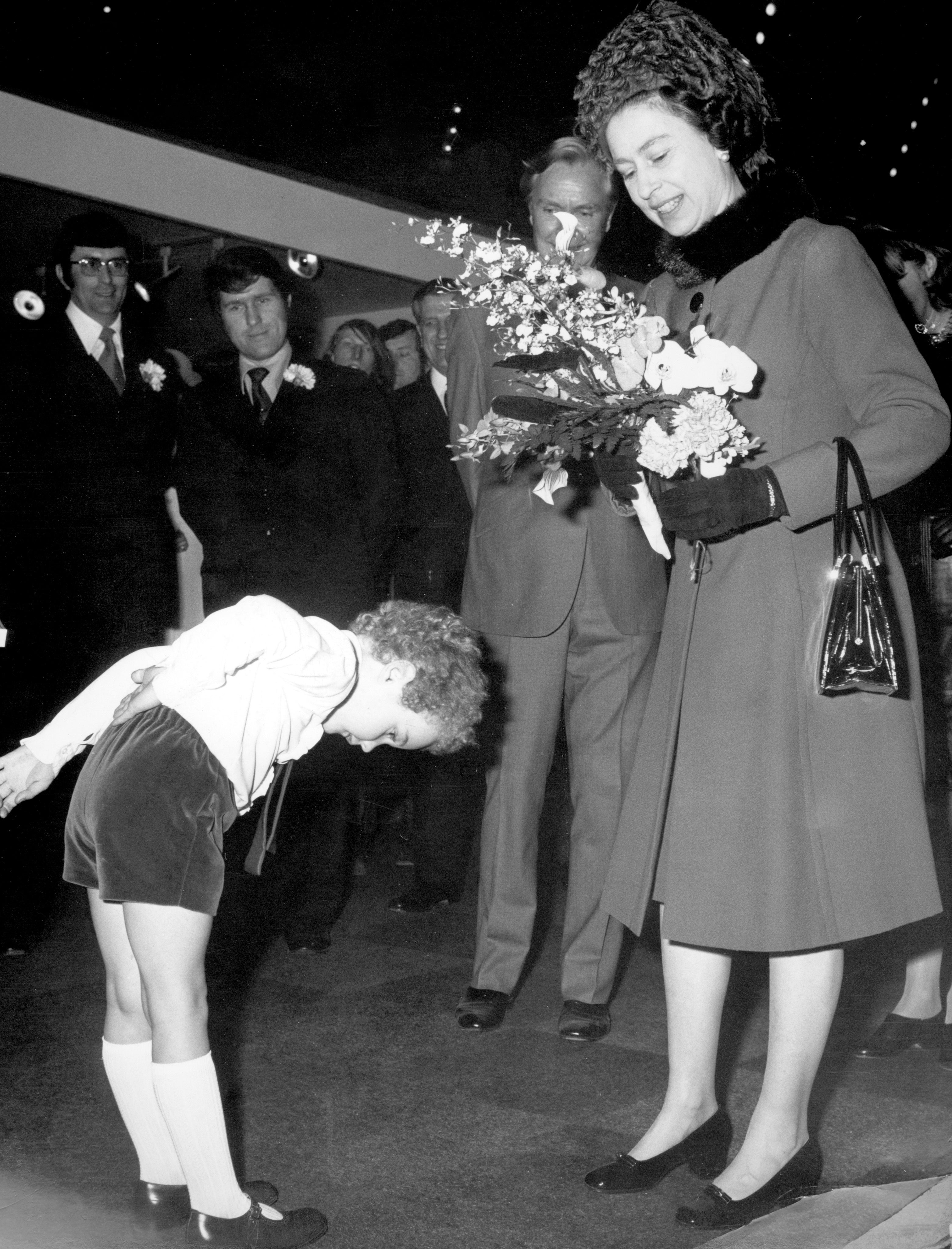 A four-year-old Harmsworth bows after presenting the Queen with a bouquet of flowers at Olympia, where the 50th Daily Mail Ideal Home Exhibition was taking place, in March 1973