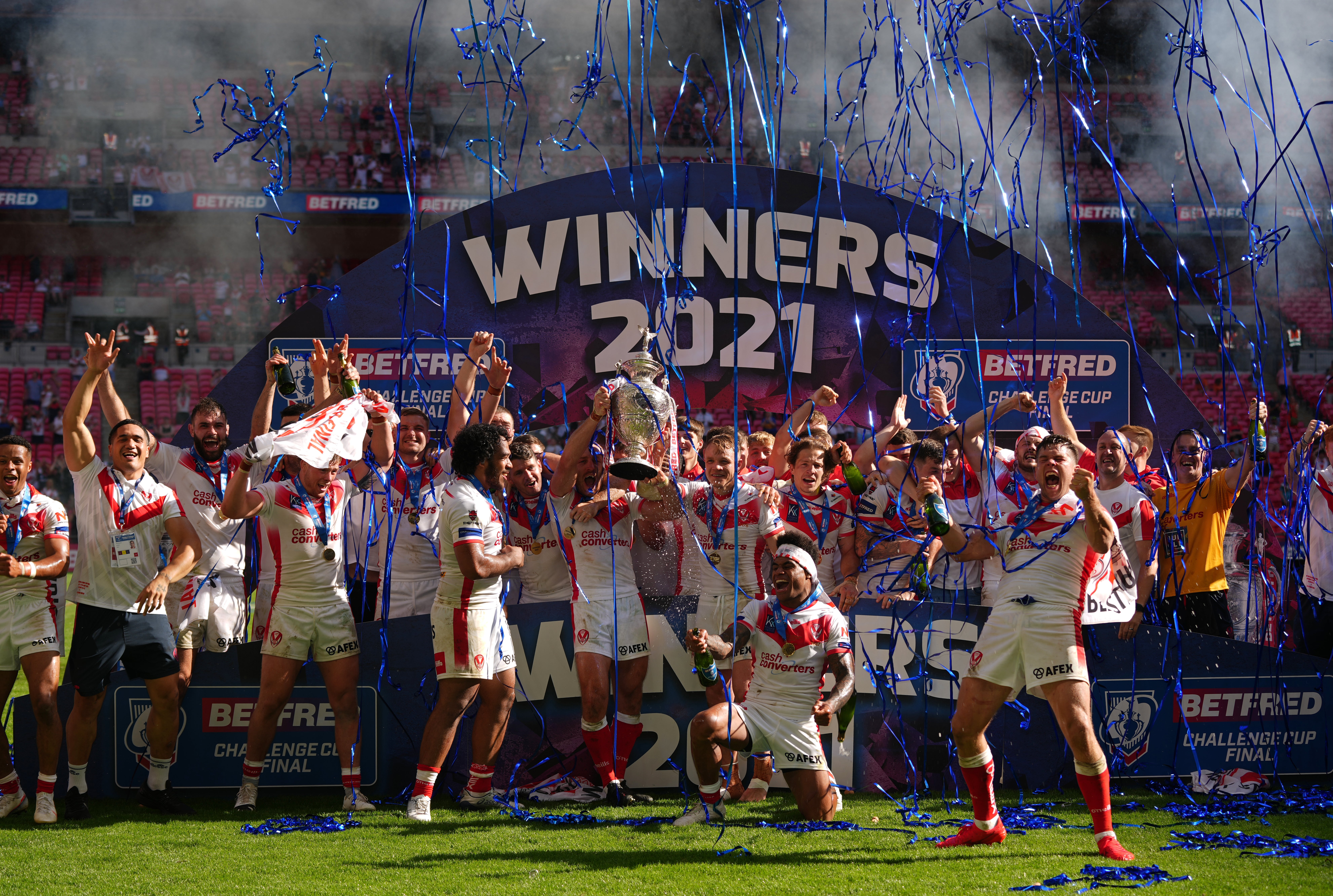 St Helens’ James Roby, centre, lifts the trophy