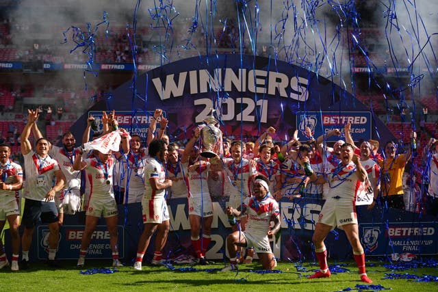 St Helens’ James Roby, centre, lifts the trophy