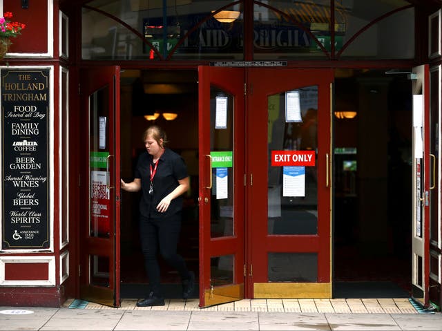 <p>Staff open the doors of The Holland Tringham Wetherspoons pub in London</p>