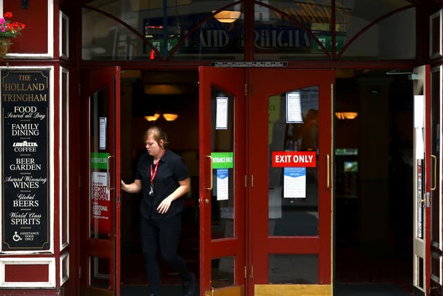 <p>Staff open the doors of The Holland Tringham Wetherspoons pub in London</p>