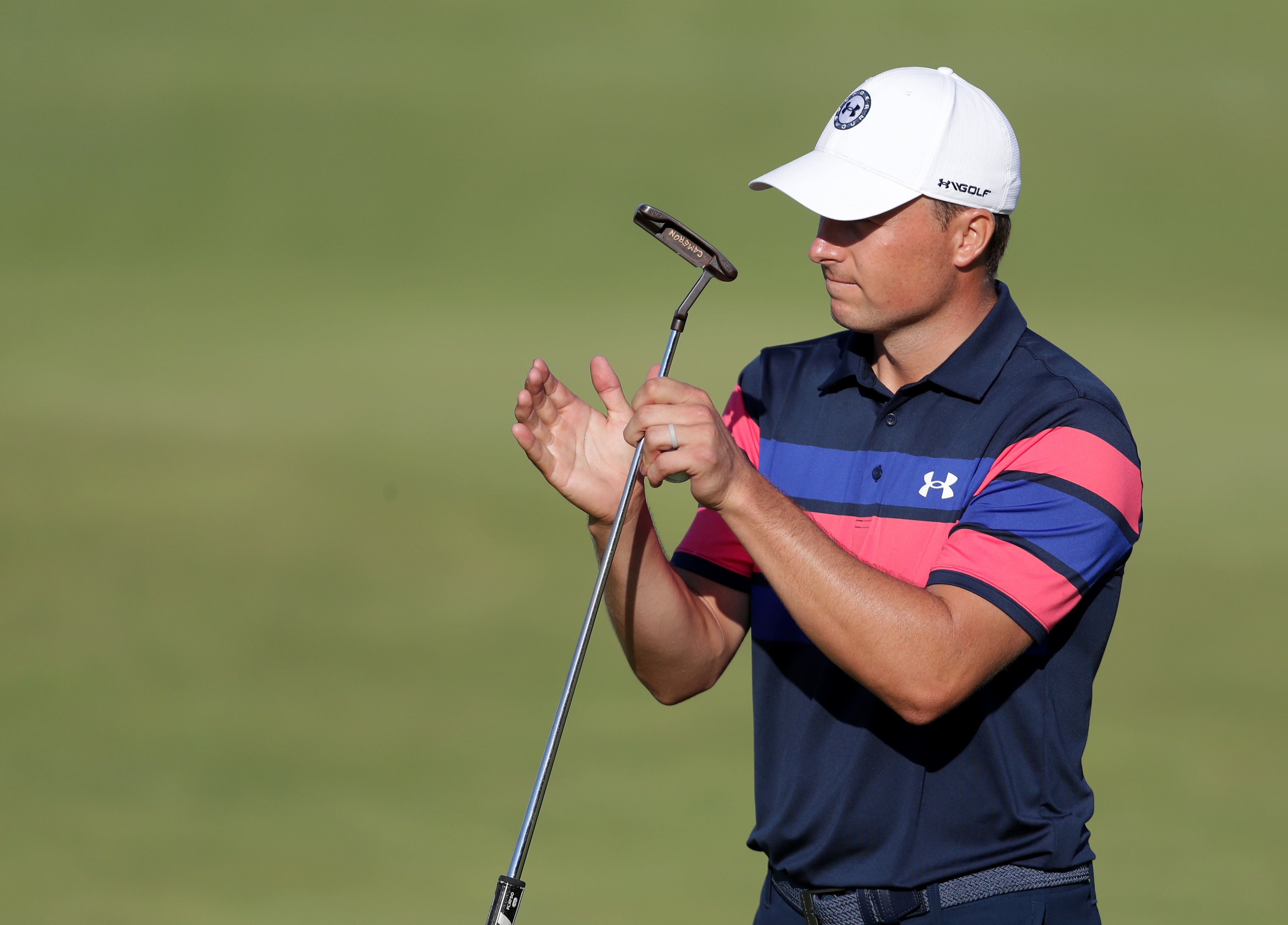 Jordan Spieth holds his putter between his hands