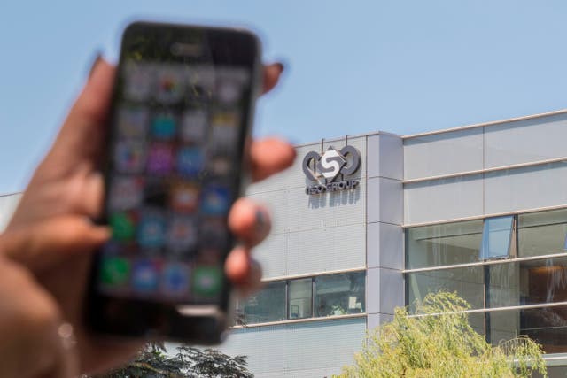 <p>File: An Israeli woman uses her iPhone in front of a building housing the Tel Aviv-based NSO group</p>