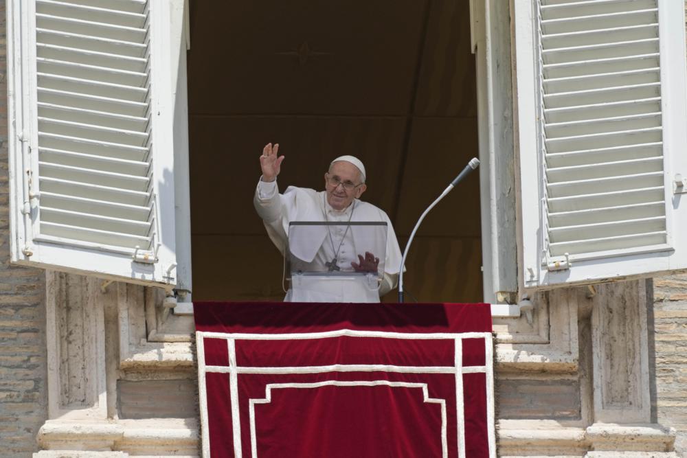 Pope Francis salutes the crowd as he arrives for the Angelus noon prayer