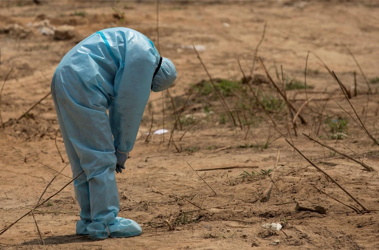 A health worker reacts before the burial of a Central Reserve Police Force officer who was died of complications related to Covid-19 in New Delhi