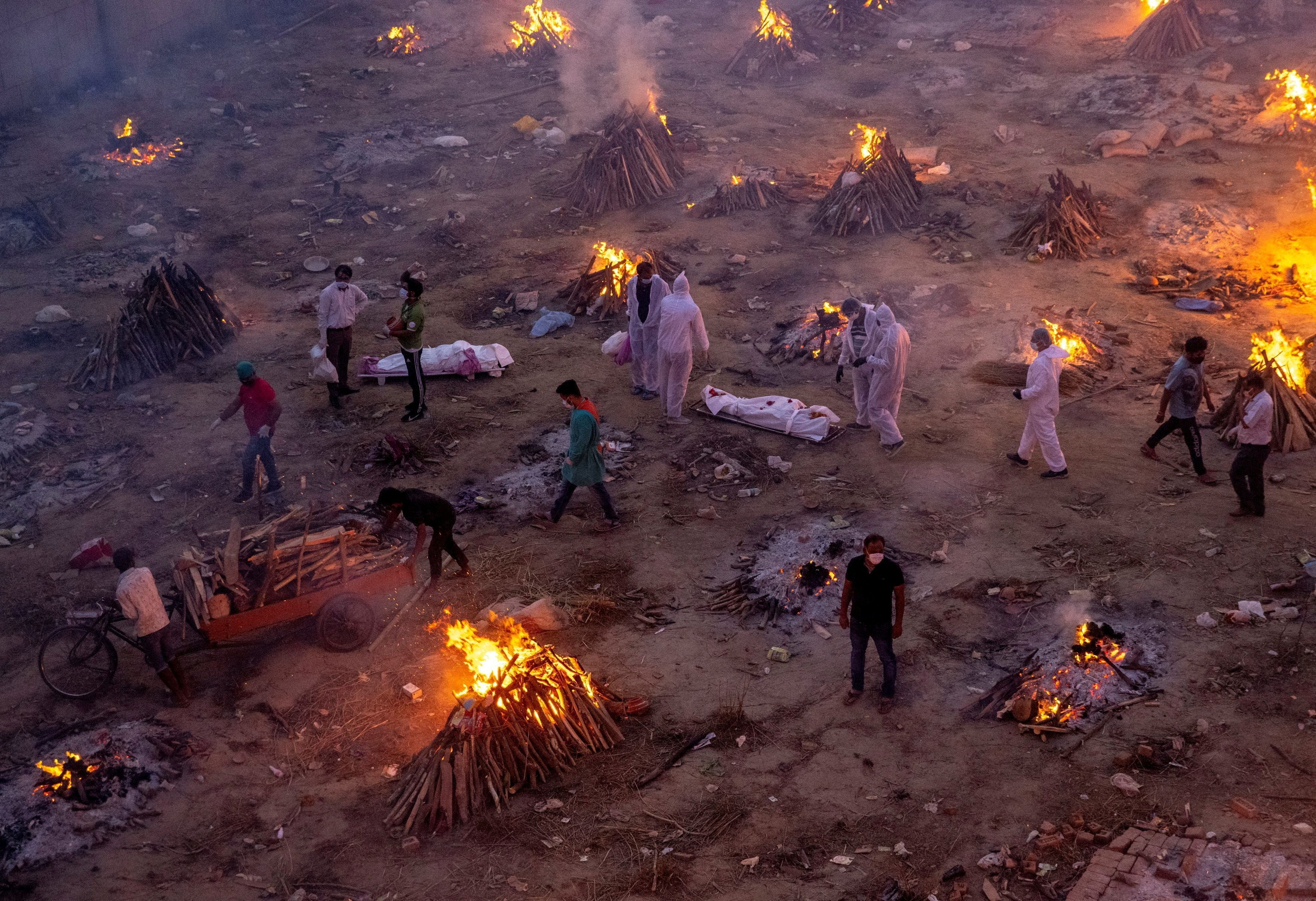 A photograph clicked by slain Reuters photojournalist Danish Siddiqui shows people wait to cremate victims who died due to Covid in India