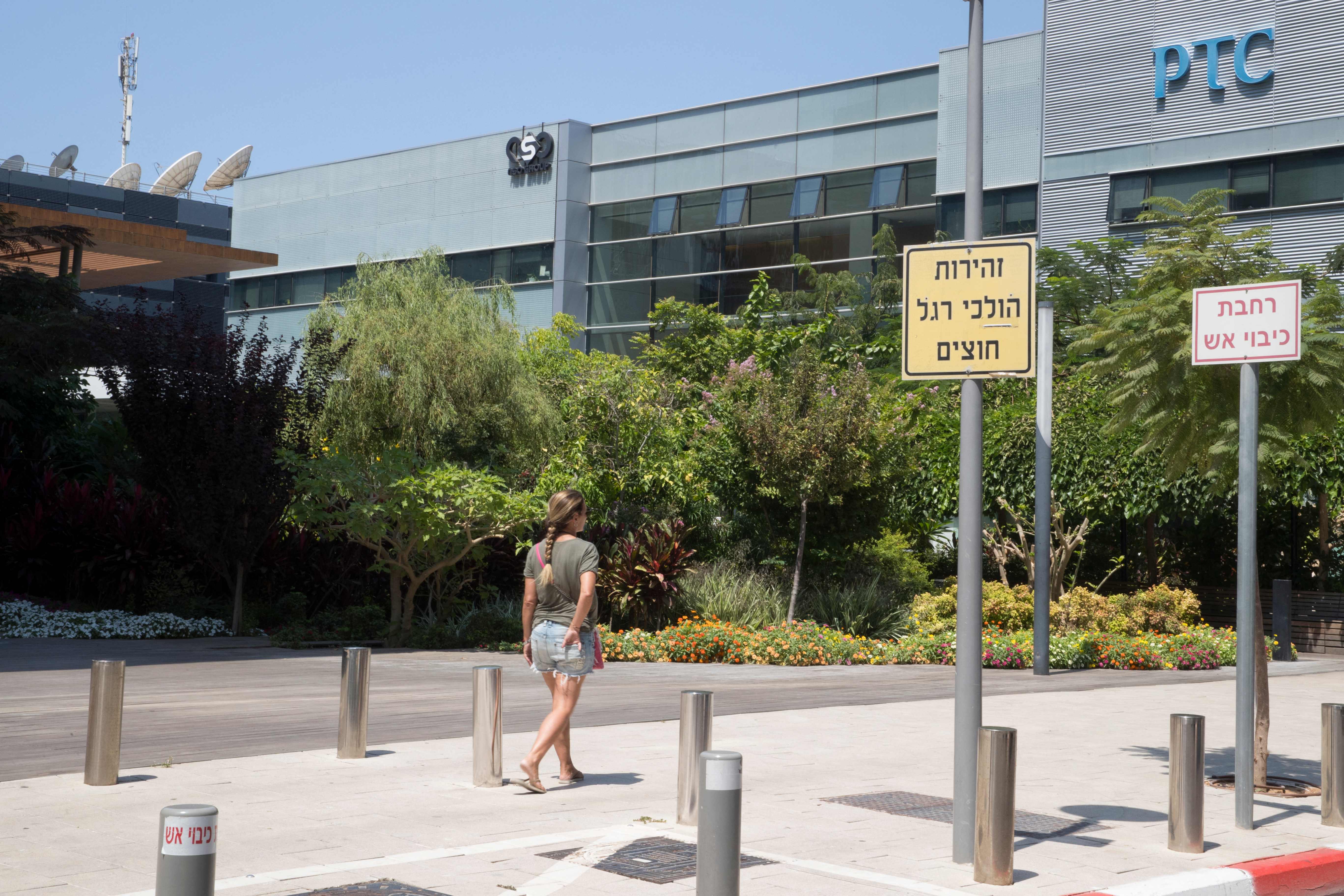 A woman walks outside the building housing the Israeli NSO group ‘Pegasus’, in Herzliya, near Tel Aviv