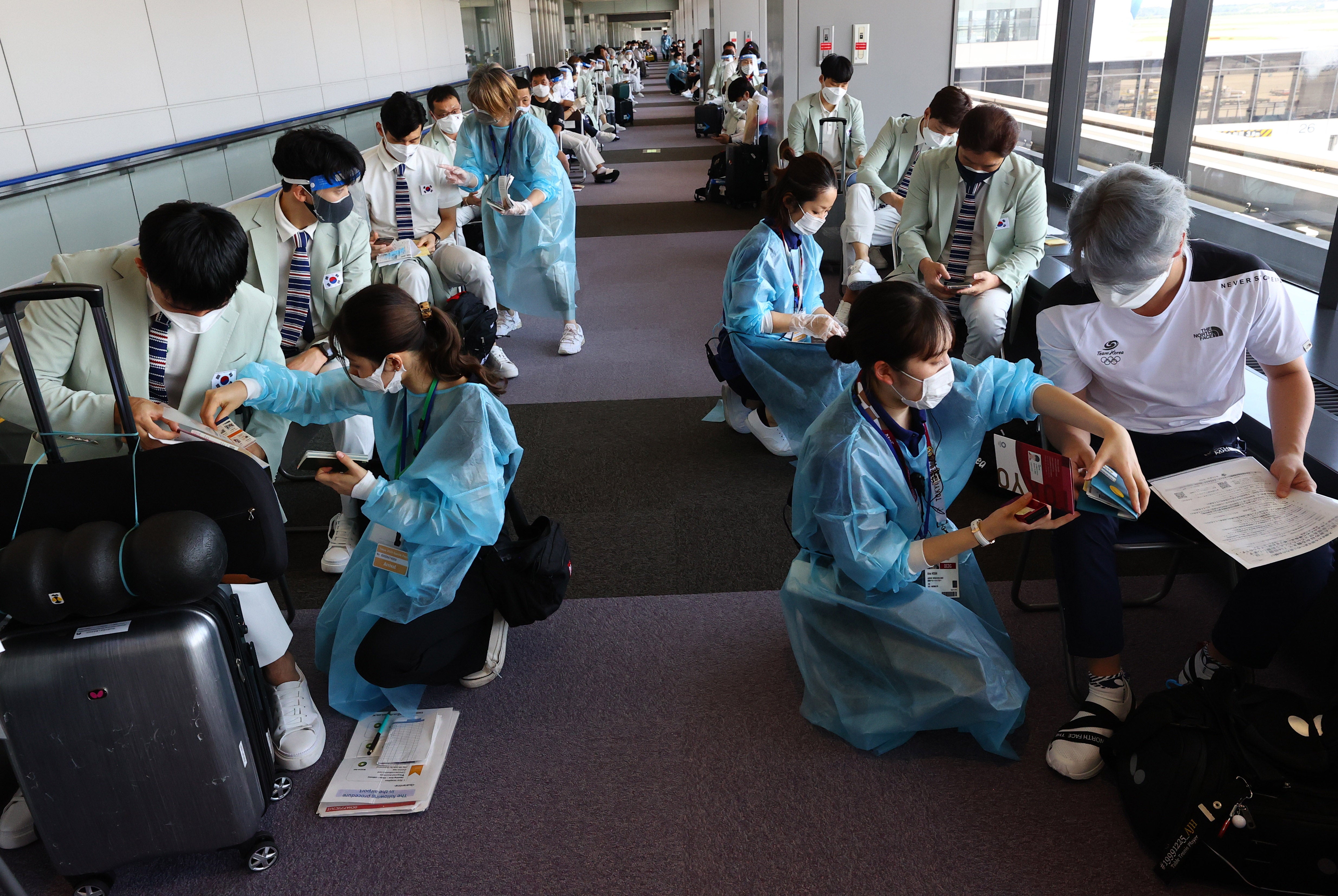 South Korea team members undergo a quarantine process after arriving at Narita International Airport on Monday, ahead of the Tokyo 2020 Olympic Games