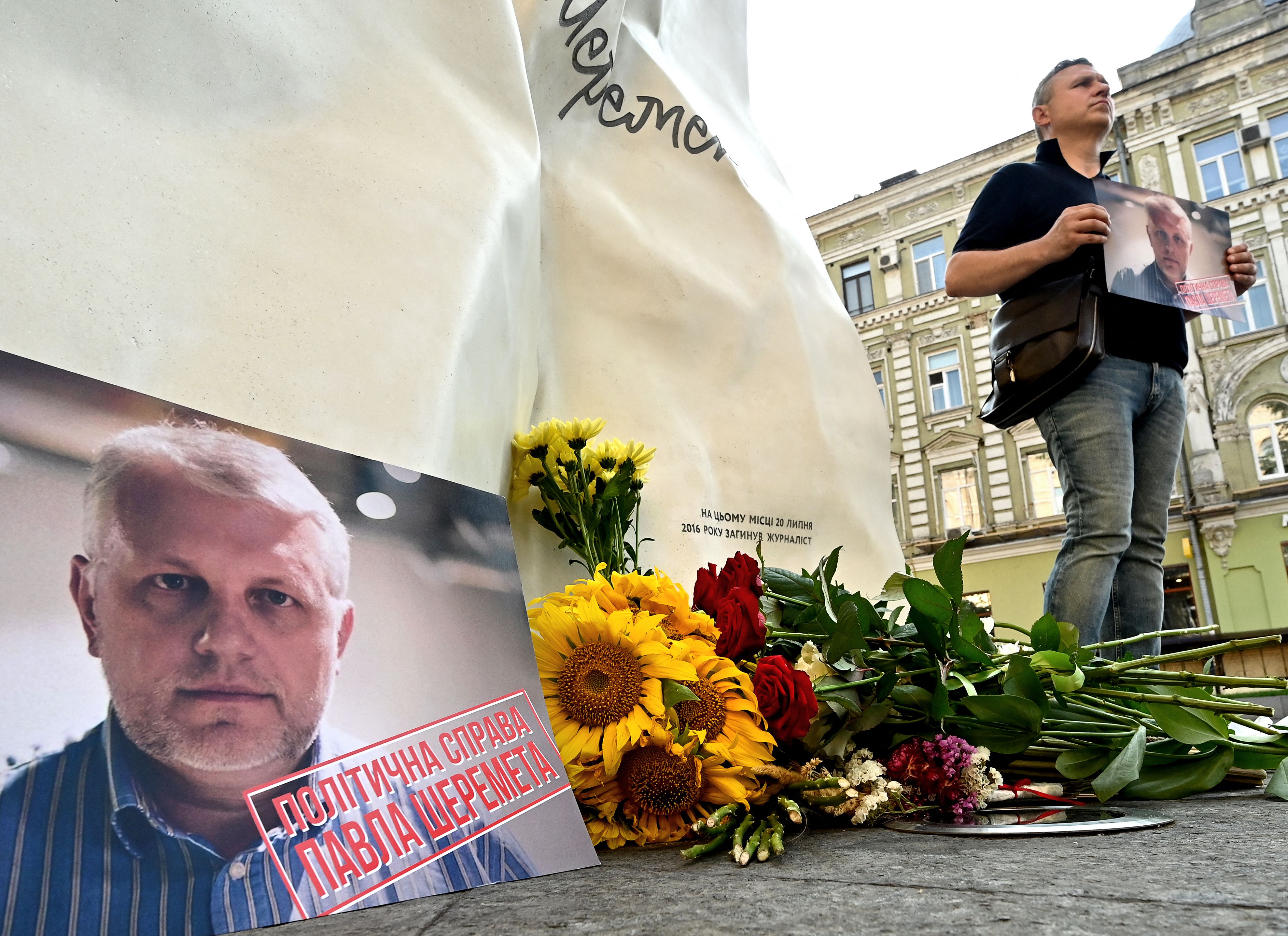 A man holds Pavel Sheremet’s portrait at his memorial in Kiev on Tuesday, on the site where the journalist’s car exploded five years ago