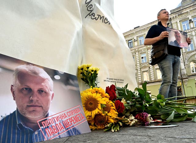 <p>A man holds Pavel Sheremet’s portrait at his memorial in Kiev on Tuesday, on the site where the journalist’s car exploded five years ago</p>