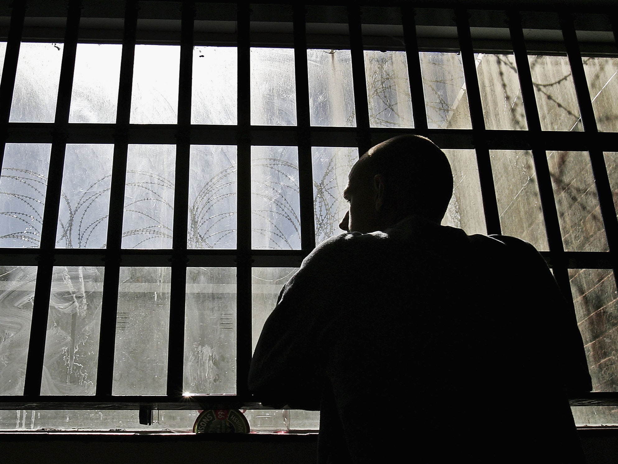 An inmate looks out of the window of the Young Offenders Institution attached to Norwich Prison in 2005