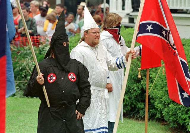<p>Members of the Ku Klux Klan stand outside a courthouse lawn in Jasper, Texas</p>