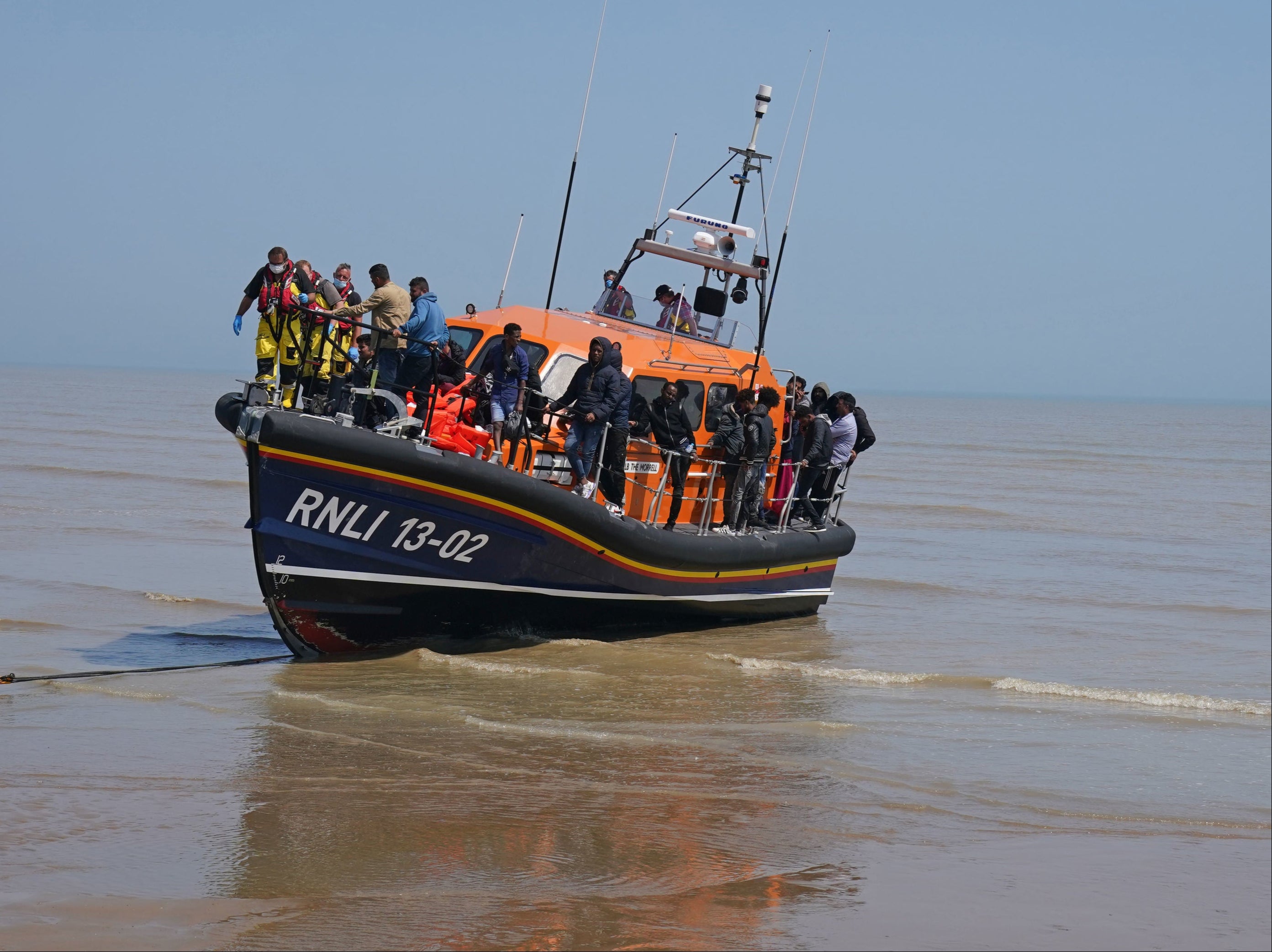 A group of people thought to be migrants crossing from France are brought ashore by the local lifeboat at Dungeness, Kent