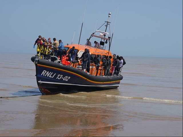 <p>A group of people thought to be migrants crossing from France are brought ashore by the local lifeboat at Dungeness, Kent</p>