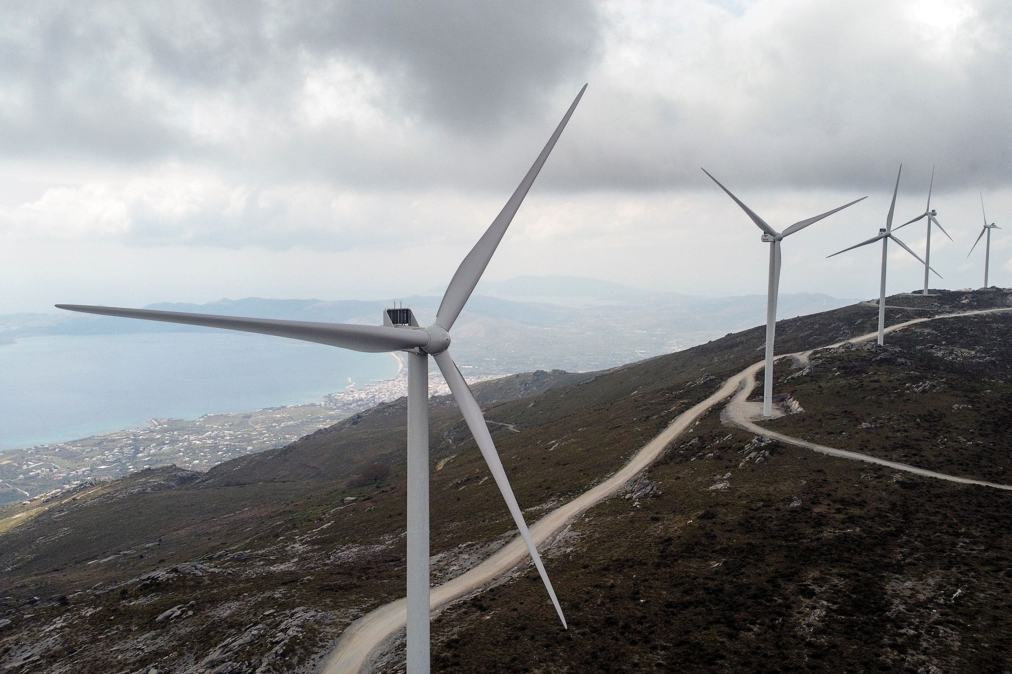Wind turbines are seen on a mountain near the town of Karystos, on the island of Evia, Greece