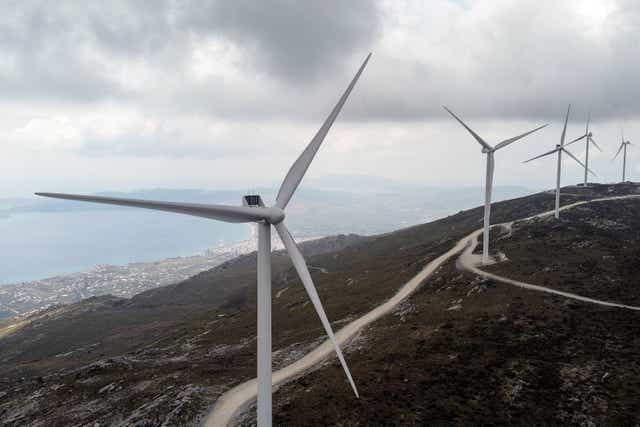 <p>Wind turbines are seen on a mountain near the town of Karystos, on the island of Evia, Greece</p>