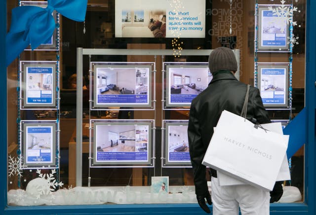 Someone looking in an estate agent's window
