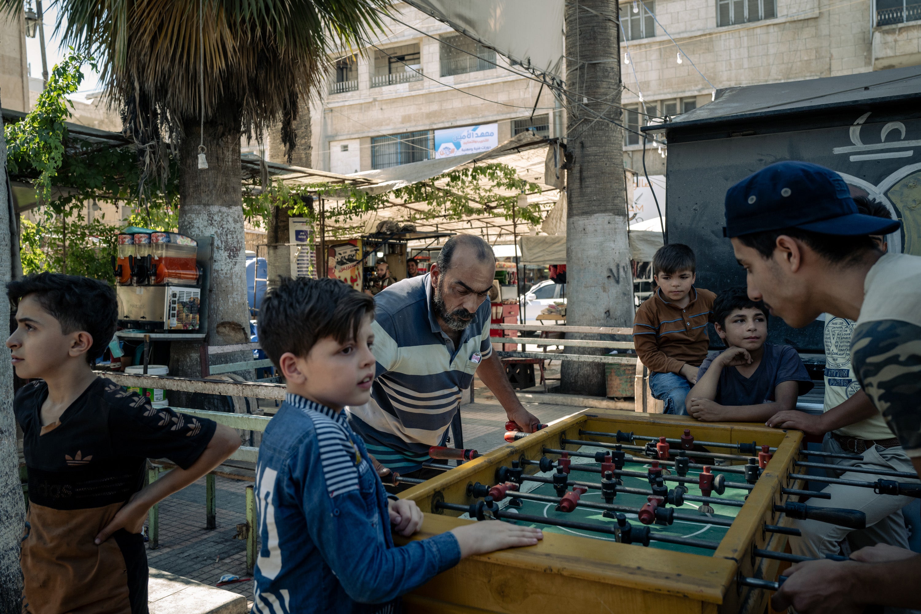 Men play table football at a square in the city of Idlib