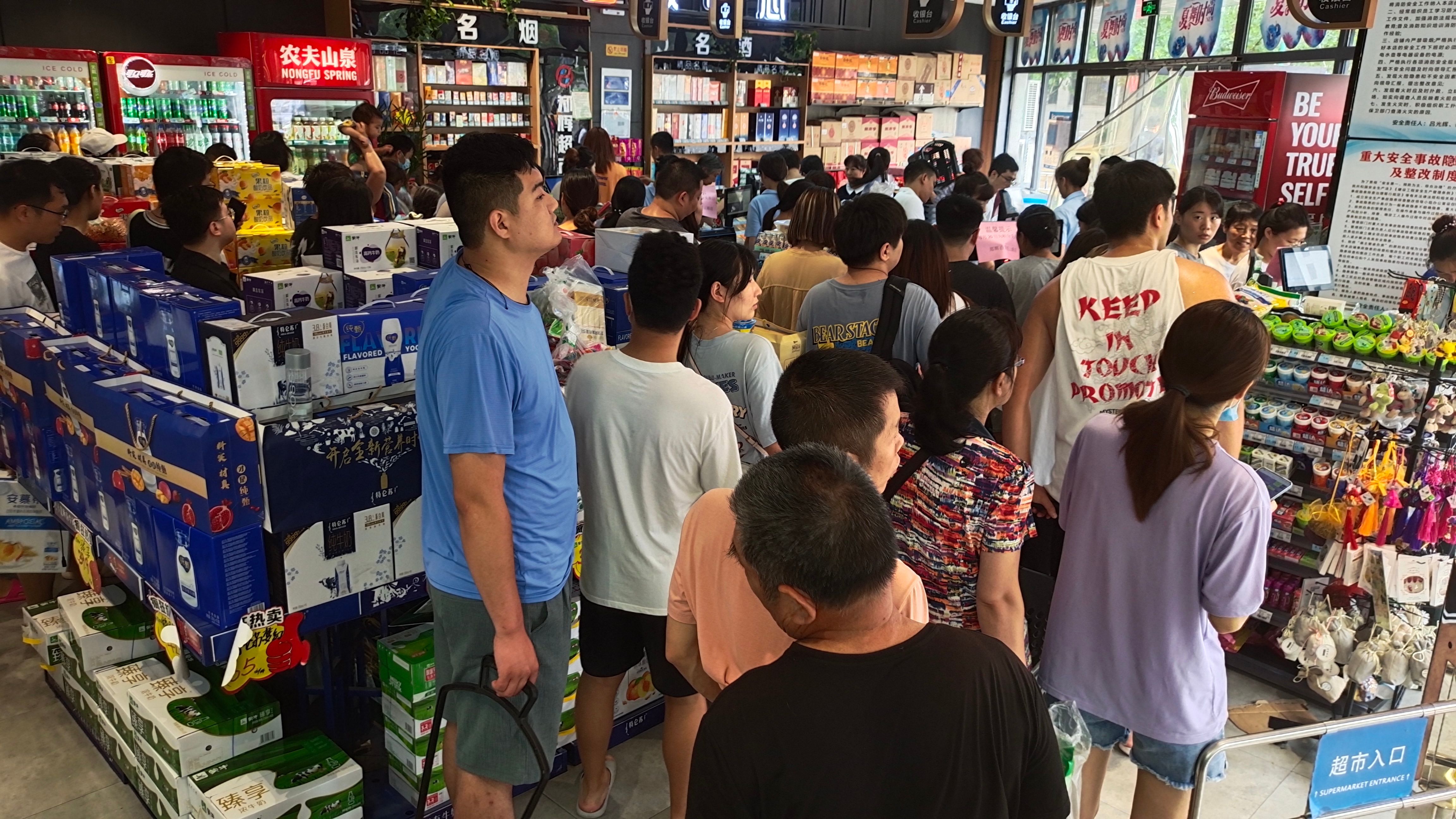 People queue for food at a supermarket in Zhengzhou, China, on Wednesday.