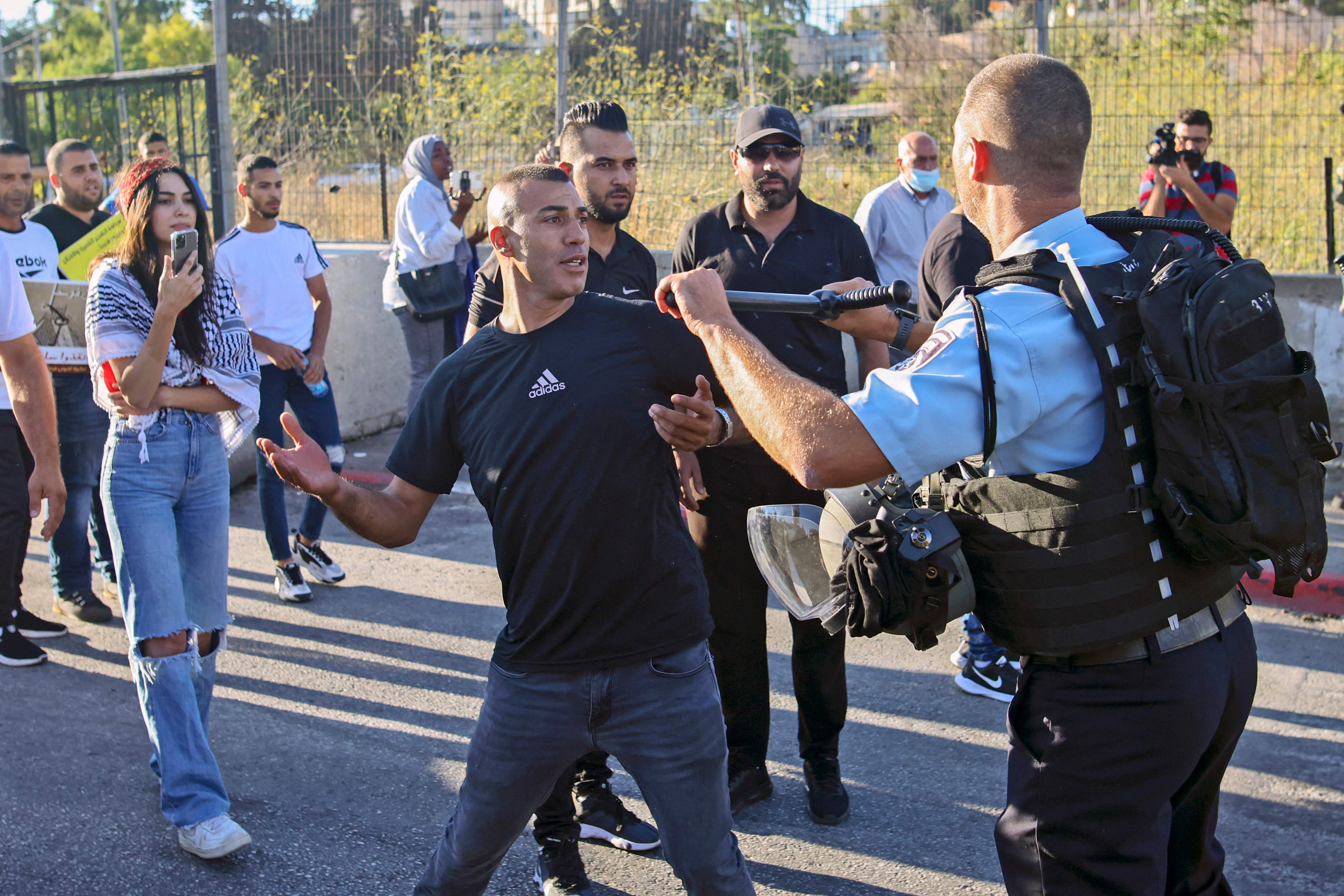 A Palestinian protester scuffles with a member of Israeli security forces near a roadblock at the entrance of the Sheikh Jarrah neighbourhood in east Jerusalem during a rally against the planned expulsion of Palestinians from houses there