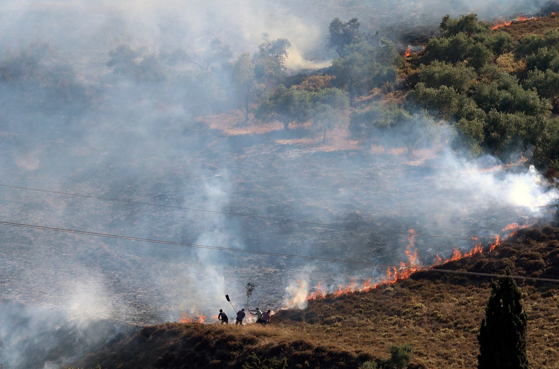 Palestinians extinguish a fire in a field around the village of Burin, south of Nablus in the occupied West Bank after Israeli settlers from the settlement of Yitzhar set it ablaze on 29 June, according to eyewitnesses from the village council