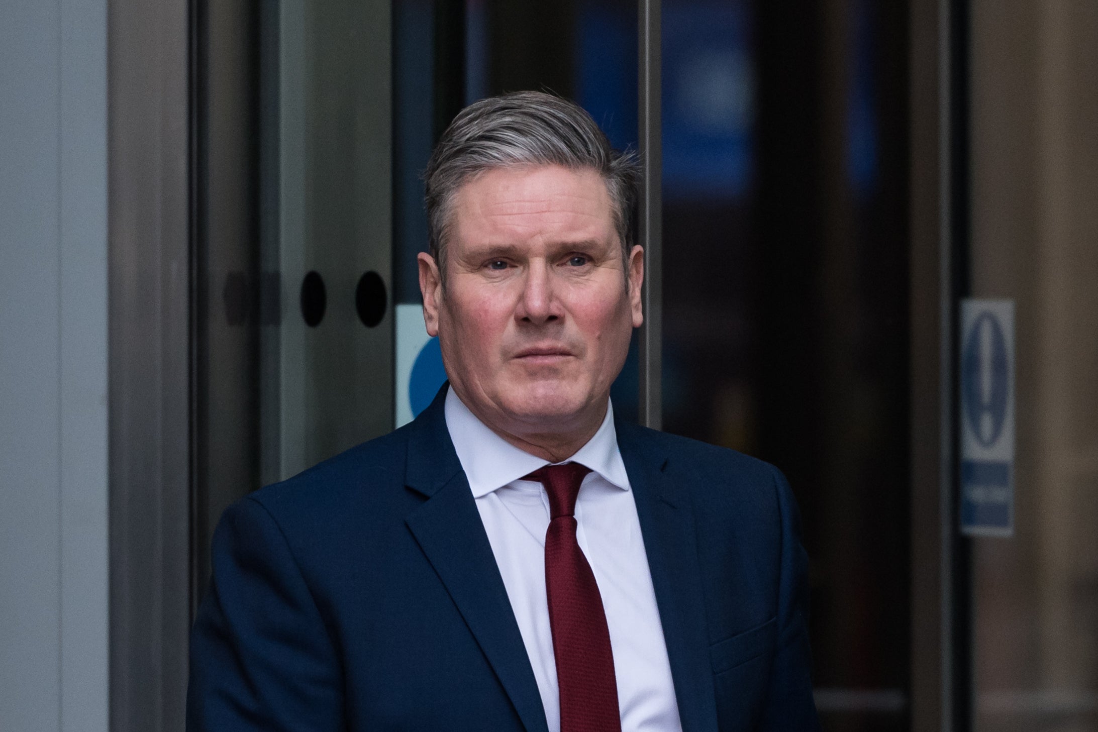Keir Starmer, coming out of a revolving door
