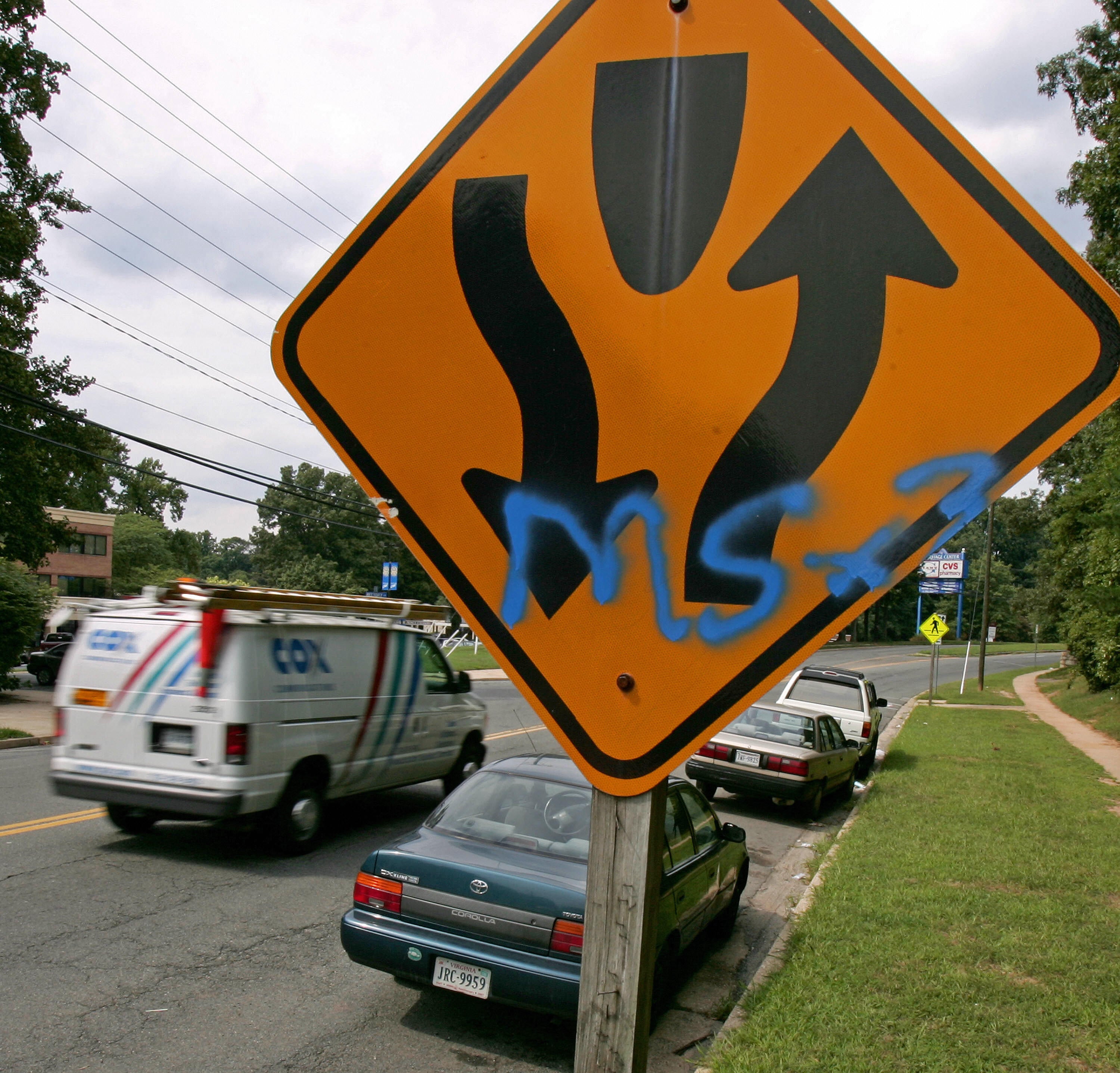A typical traffic sign carries an extra message indicating it as territory for the El Salvaldorian gang MS-13 near Annandale High School in the Washington DC, suburb of Annandale, Virginia.