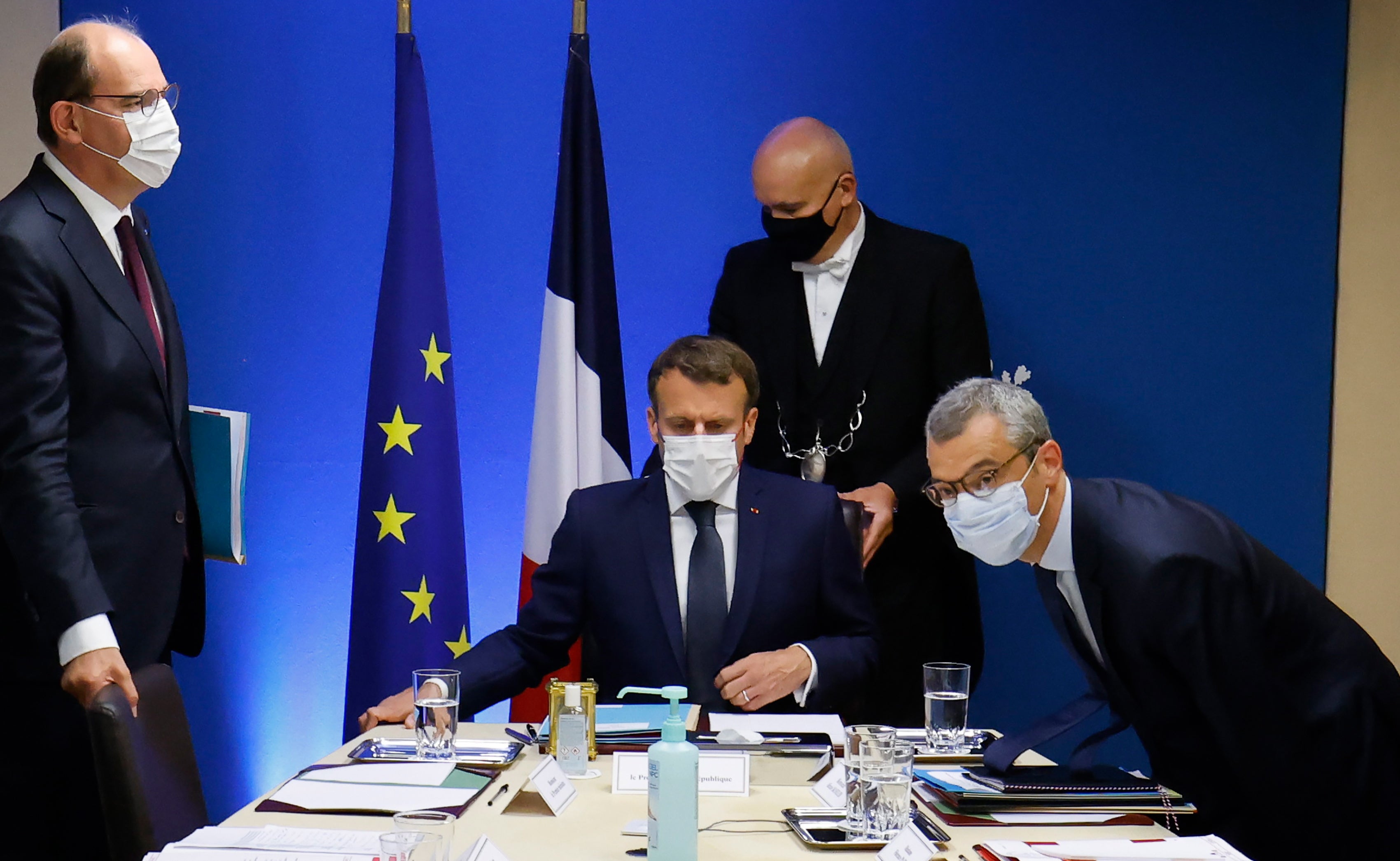 French President Emmanuel Macron (C) flanked by French Prime Minister Jean Castex (L) and Secretary General of the Elysee Palace Alexis Kohler (R) starts a national security meeting to discuss Pegasus spyware in the Jupiter room at The Elysee Presidential Palace in Paris, France, 22 July 2021