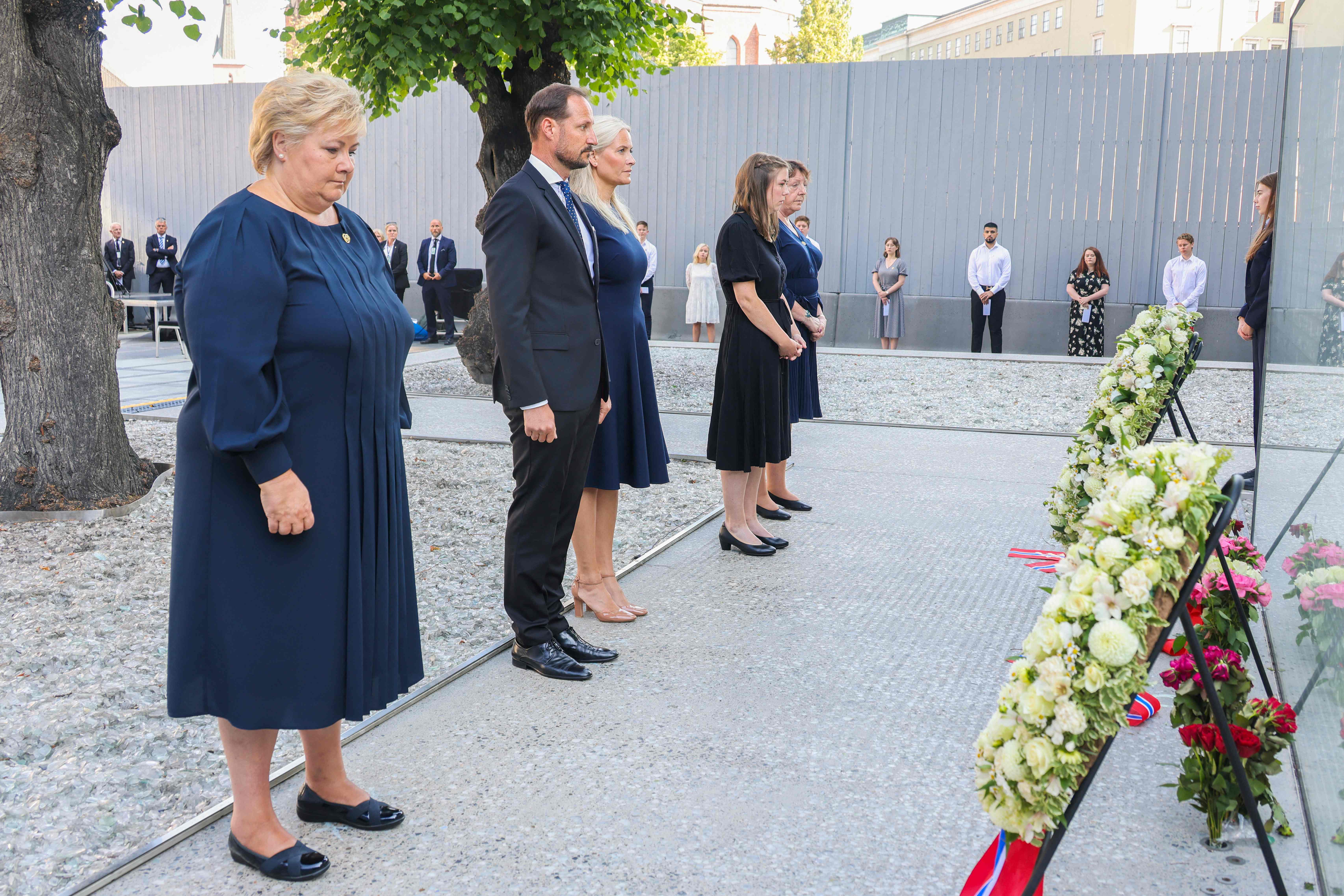 (L-R) Norway's Prime Minister Erna Solberg, Crown Prince Haakon Magnus, Crown Princess Mette-Marit, Utoya massacre survivor Astrid Eide Hoem and the leader of the National Support Group Lisbeth Kristine Royneland attend a wreath-laying ceremony during the memorial service in the Government Quarter in Oslo