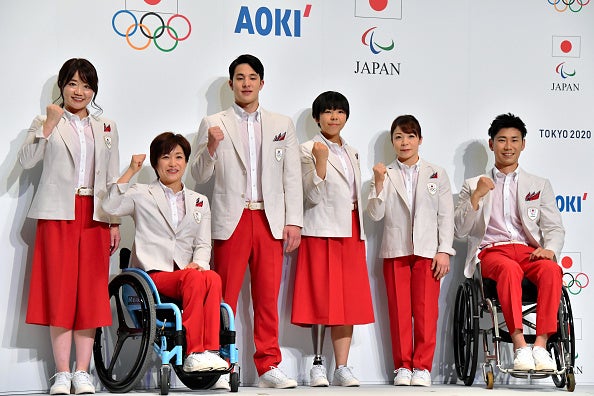 Paralympians and Olympians from the Japan team pose in their delegation uniforms for Tokyo 2020