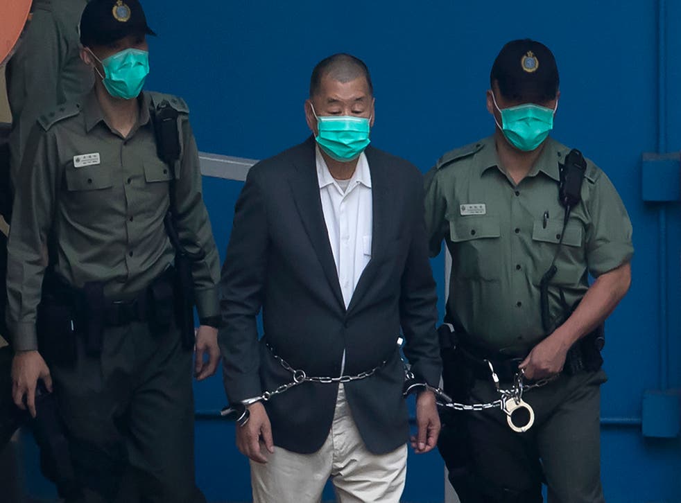 <p>Jimmy Lai, who founded the now-shuttered <em>Apple Daily</em>, is escorted by Correctional Services officers to a prison van before appearing in a court in Hong Kong on 12 December 2020</p>
