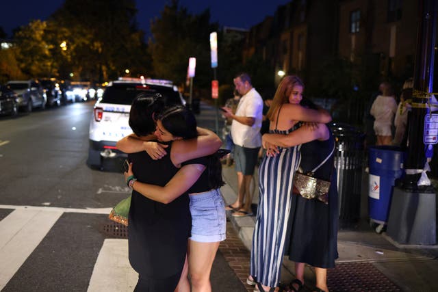 <p>People embrace near the site of a shooting on July 22, 2021 in Washington, DC</p>