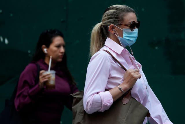 <p>People walk through Times Square on 22 July  2021, as the Delta Covid surge is renewing calls for mask mandates in New York</p>
