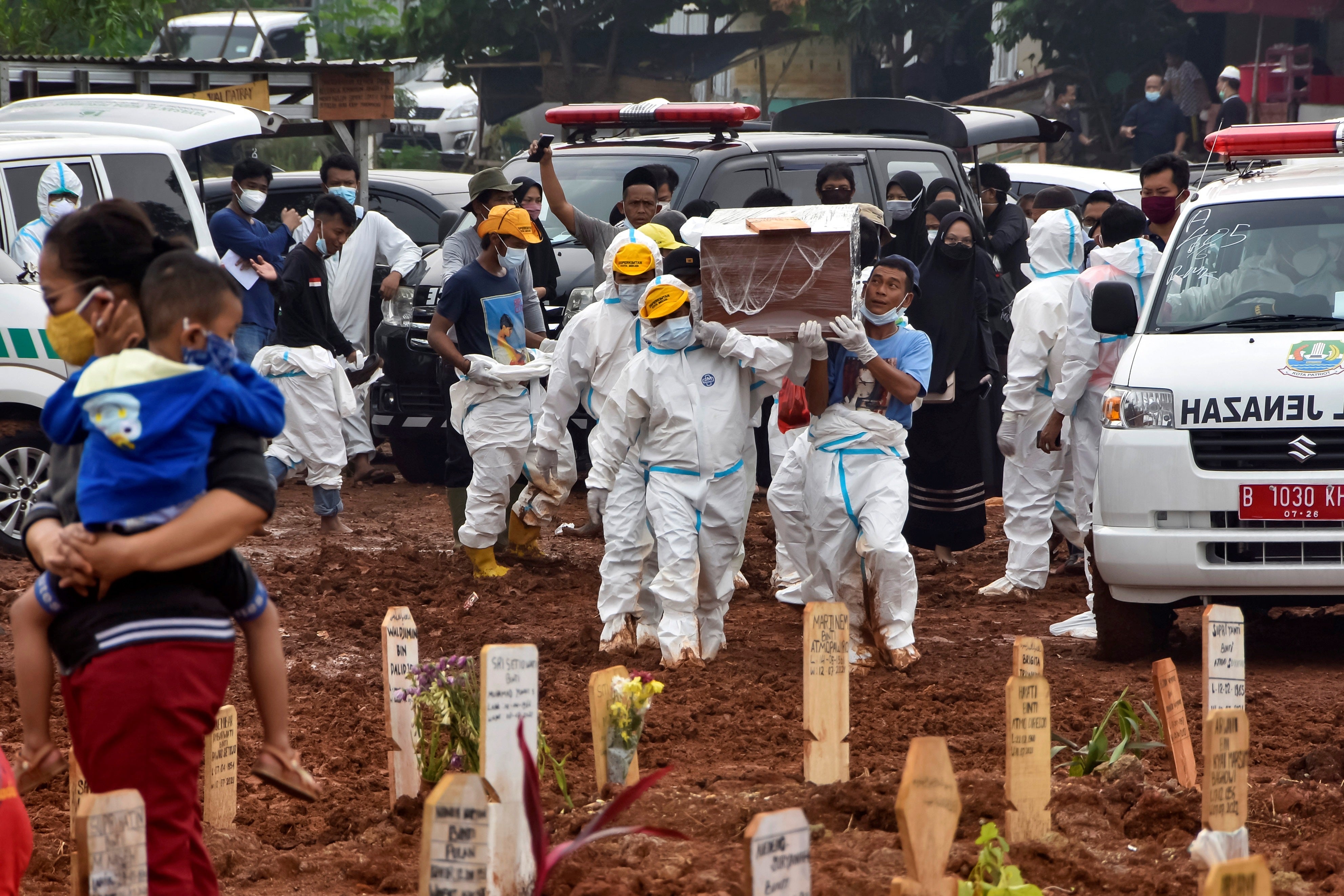 Funeral workers prepare to bury deceased Covid-19 coronavirus victims who were brought by ambulance directly from hospitals, at the Pedurenan public cemetery in Bekasi, West Java on 23 July 2021