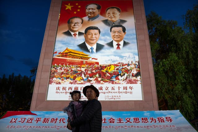 <p>File image: A man holds a girl as they pose for a photo in front of a large mural depicting Chinese President Xi Jinping, bottom centre, and other Chinese leaders at a public square at the base of the Potala Palace in Lhasa in western China's Tibet Autonomous Region on 1 June, 2021. </p>